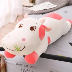 La compagnie de la peluche Peluche vache coloré qui broute de l'herbe