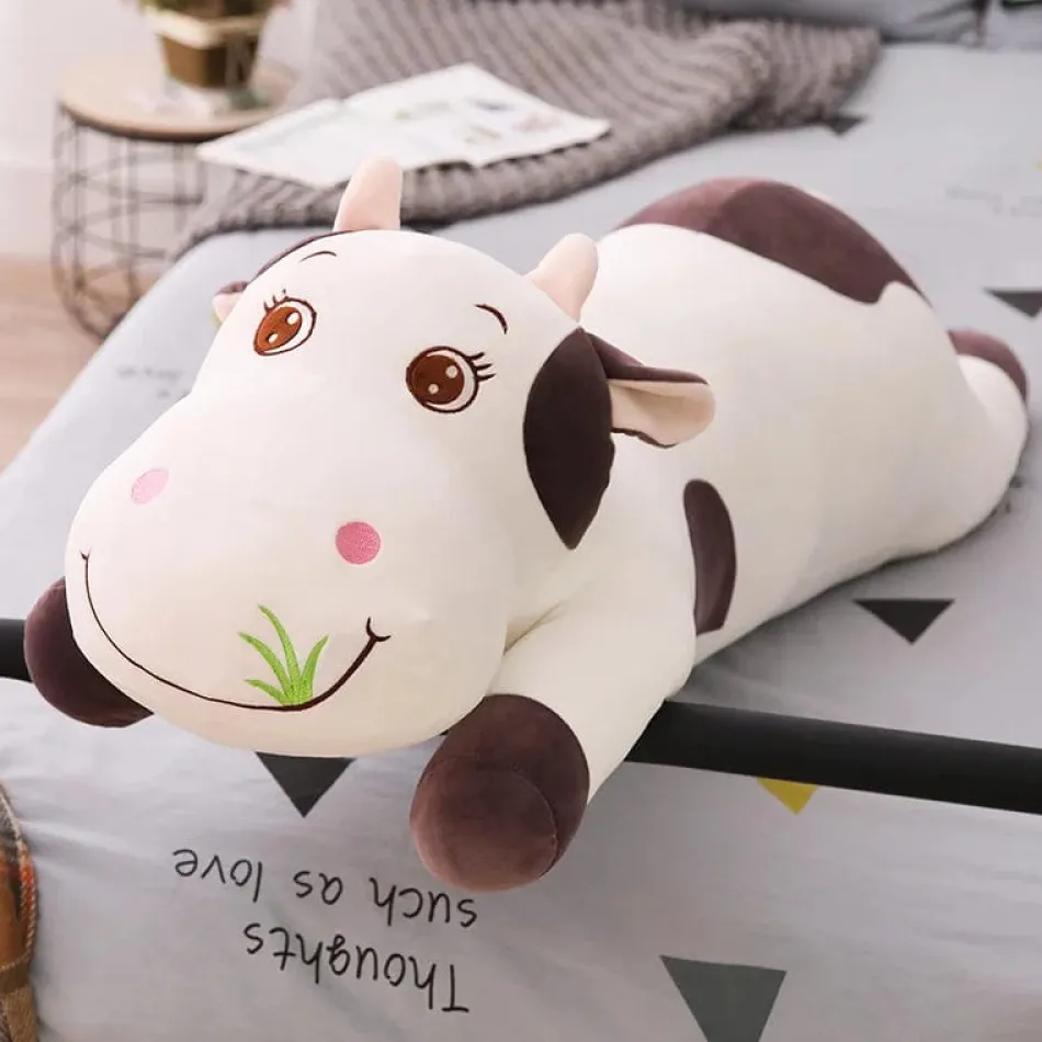 La compagnie de la peluche Peluche vache coloré qui broute de l'herbe